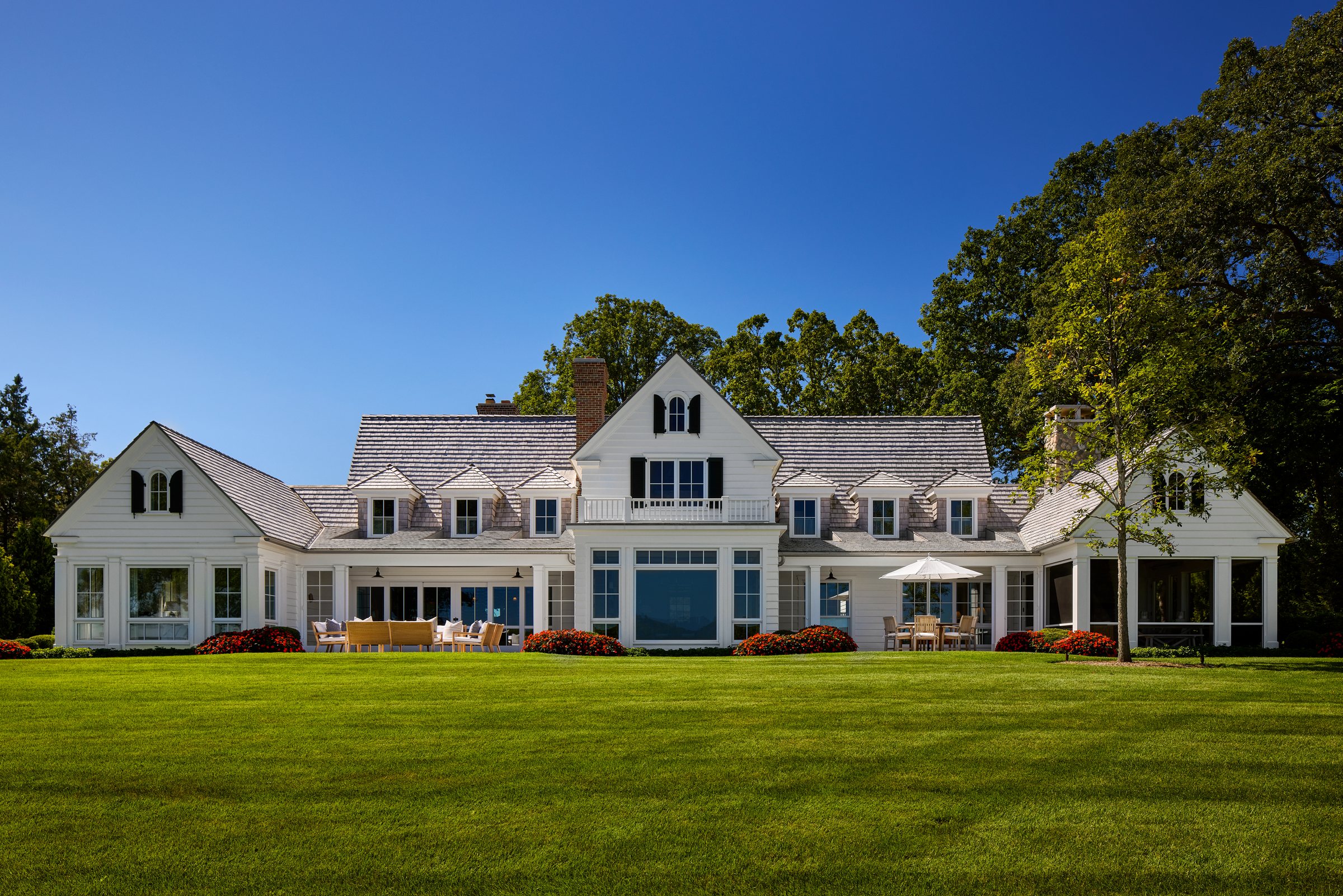 Lawn and waterfront view of the shingle-style home