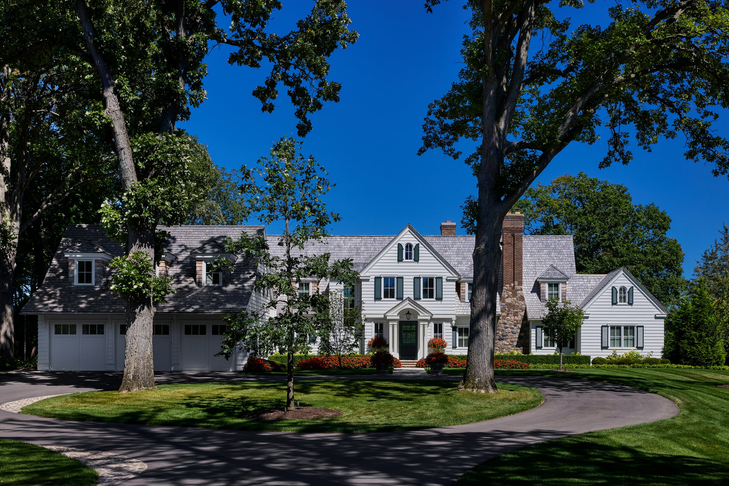 Shingle-style home with a fieldstone chimney