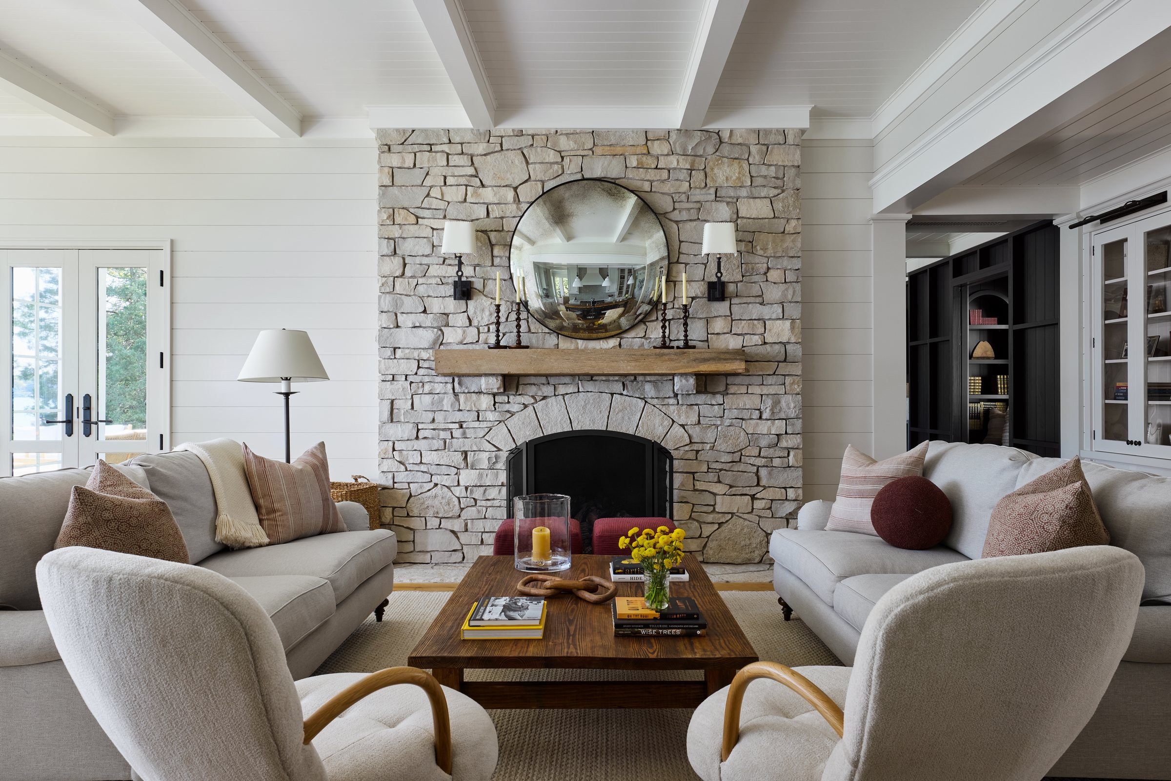 Living room with a floor-to-ceiling stone fireplace and lake views
