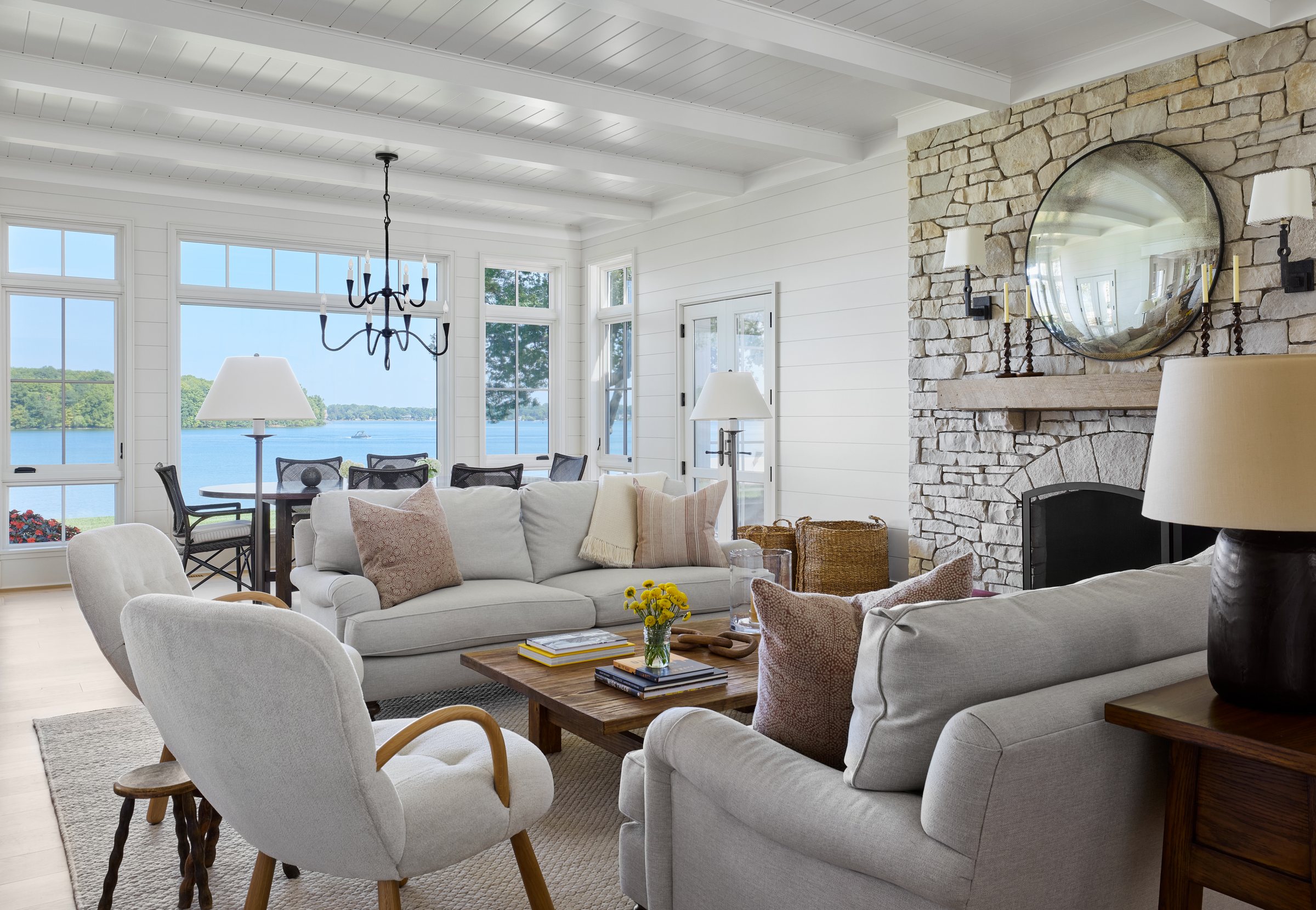 Living room with a stone fireplace and windows to the lake