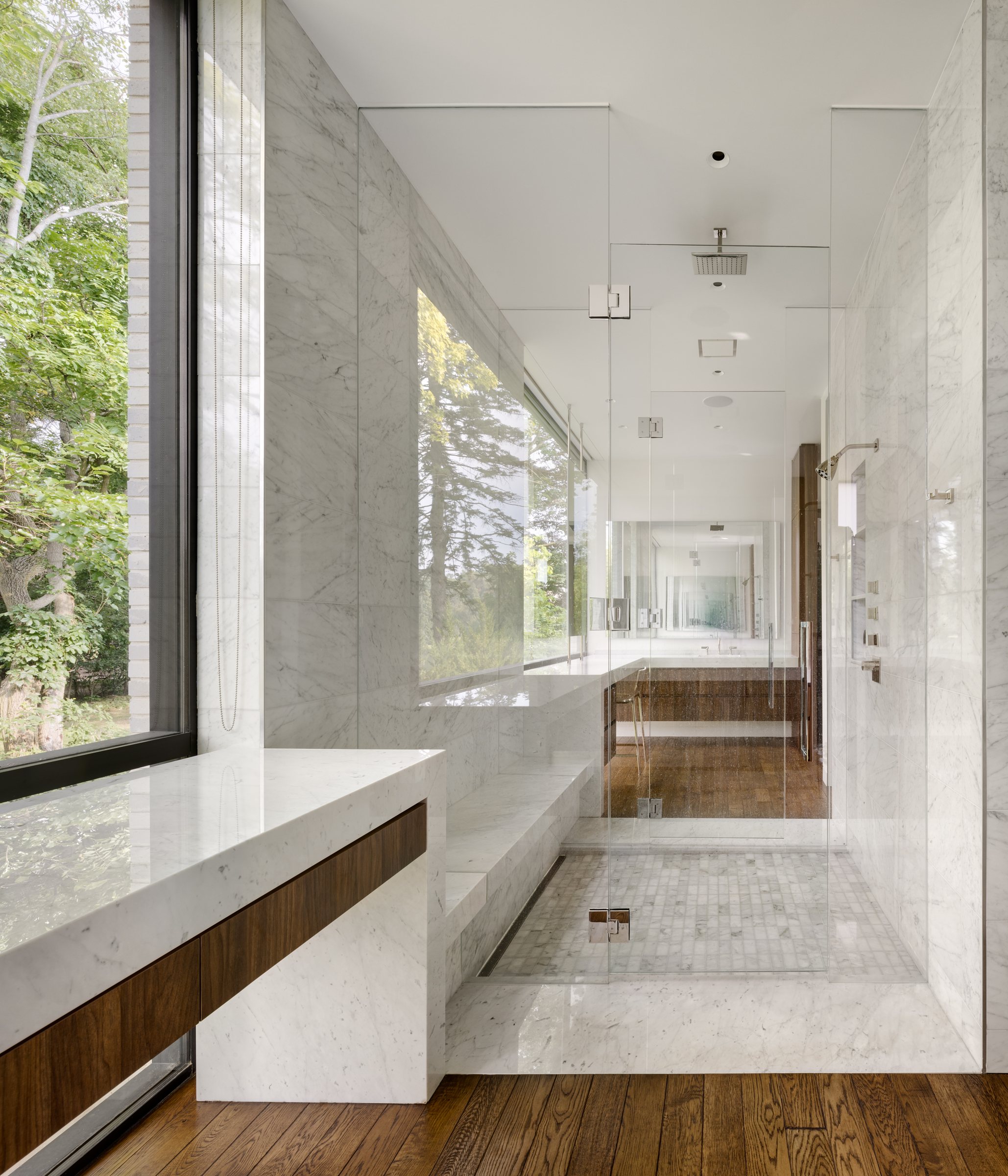 Marble primary bath with a window to the trees