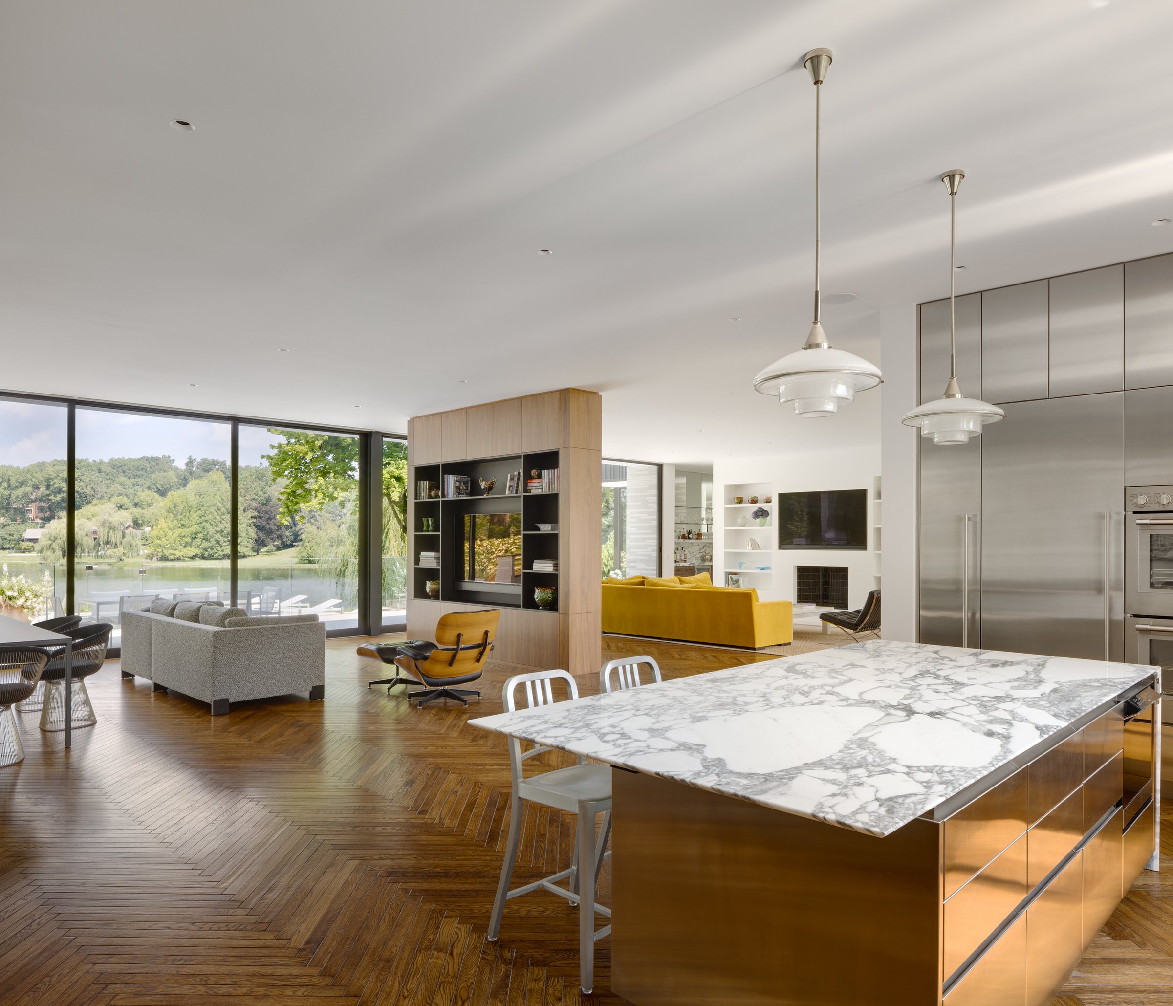 Kitchen with a book-matched marble island and stainless steel cabinetry, open to the lake