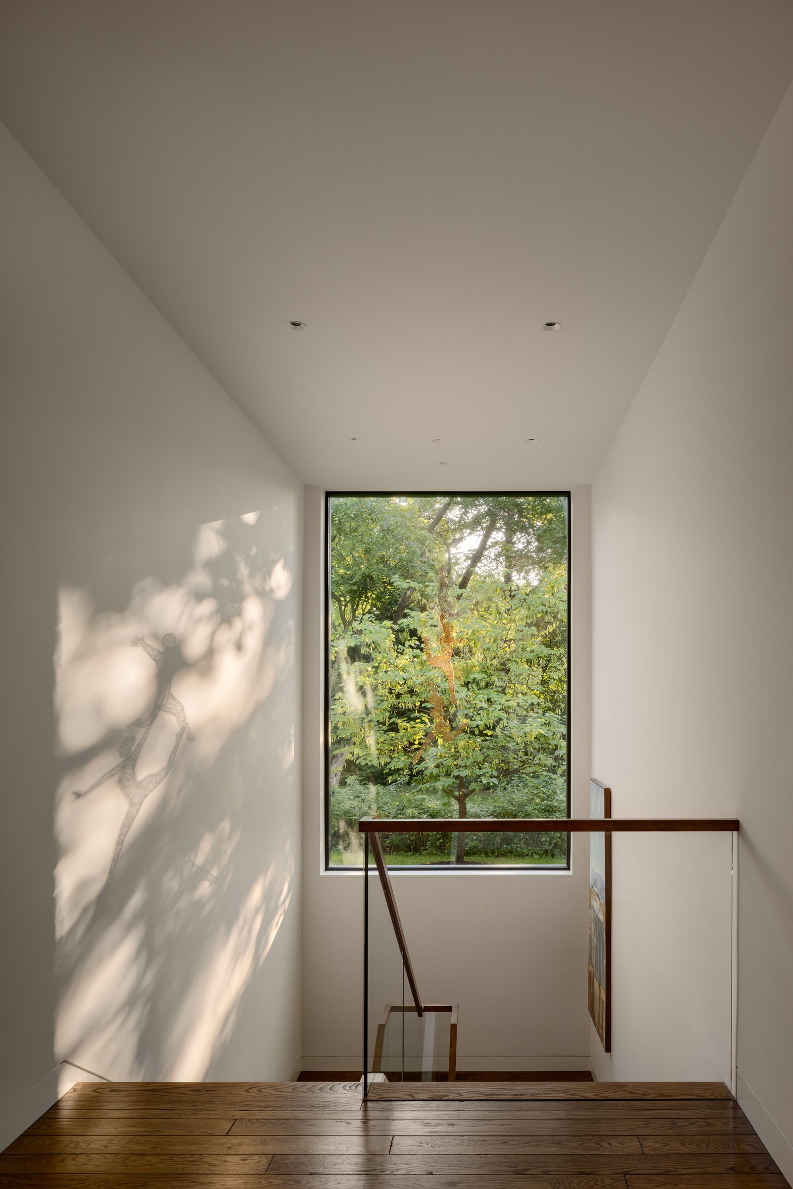 Stair landing lit by a tall window