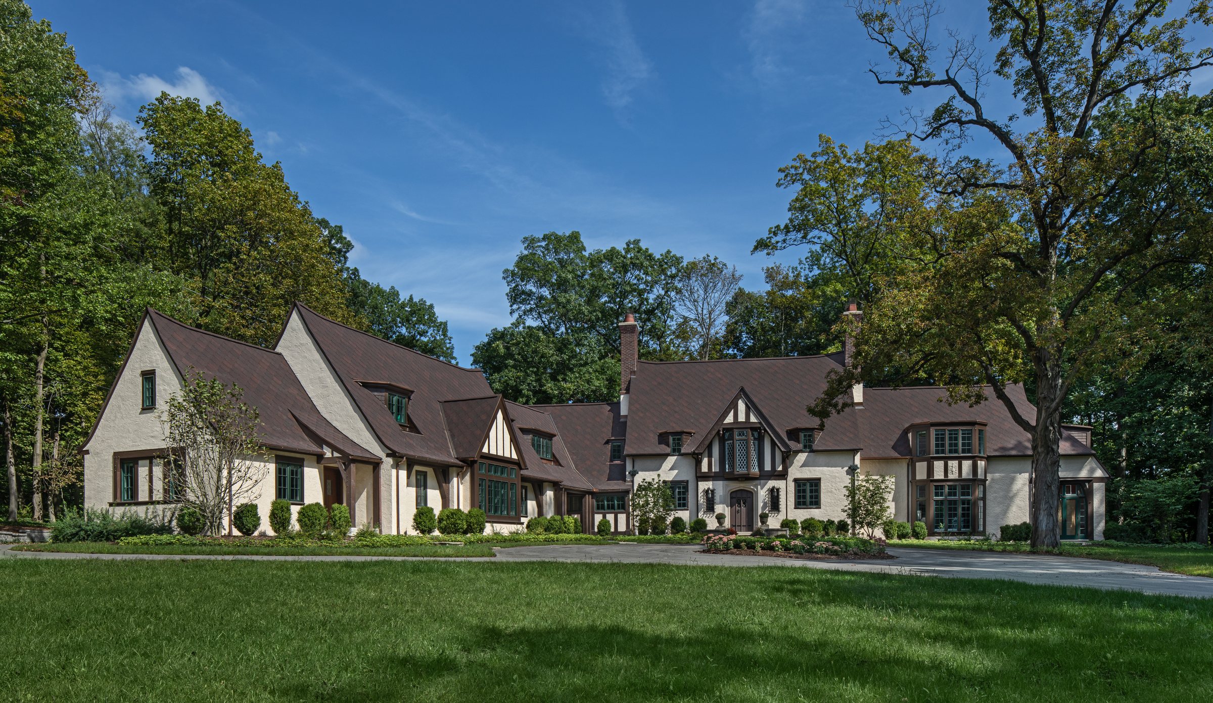 English Tudor with steep gables, brick, stucco, and leaded glass
