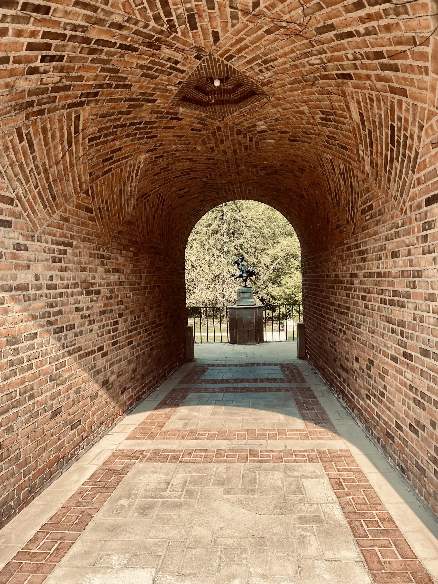 Brick barrel-vaulted passage with a patterned stone floor