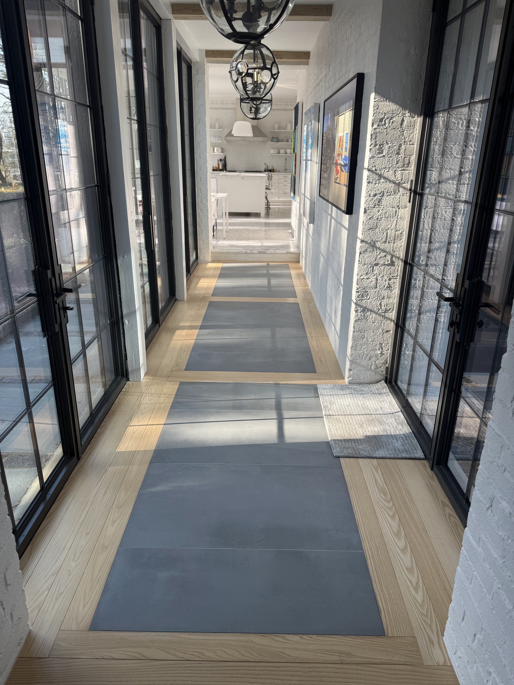 Hallway of steel-framed glass and white brick, floored in oak