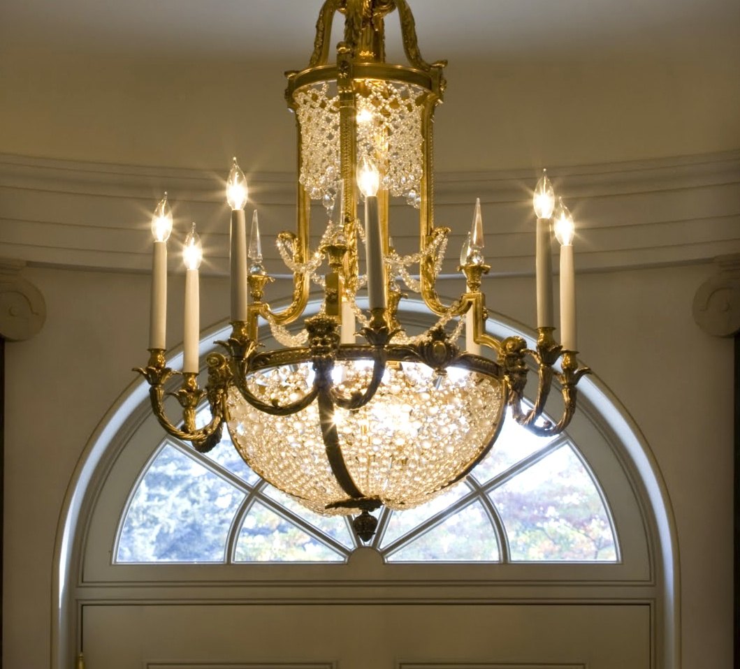 The entry chandelier in gilt bronze and crystal, before the fanlight