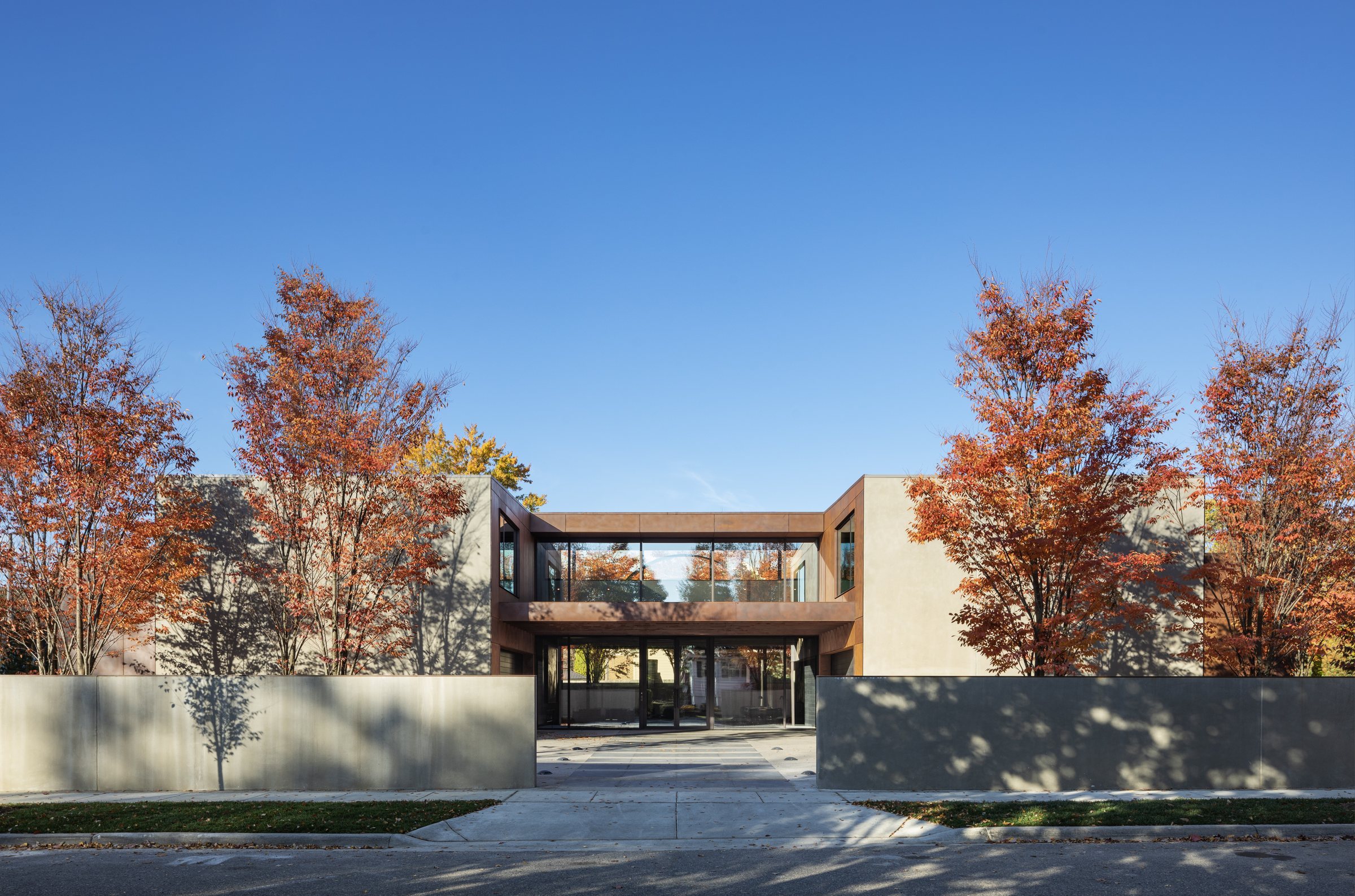 Modern in the Trees, seen from the street through autumn maples