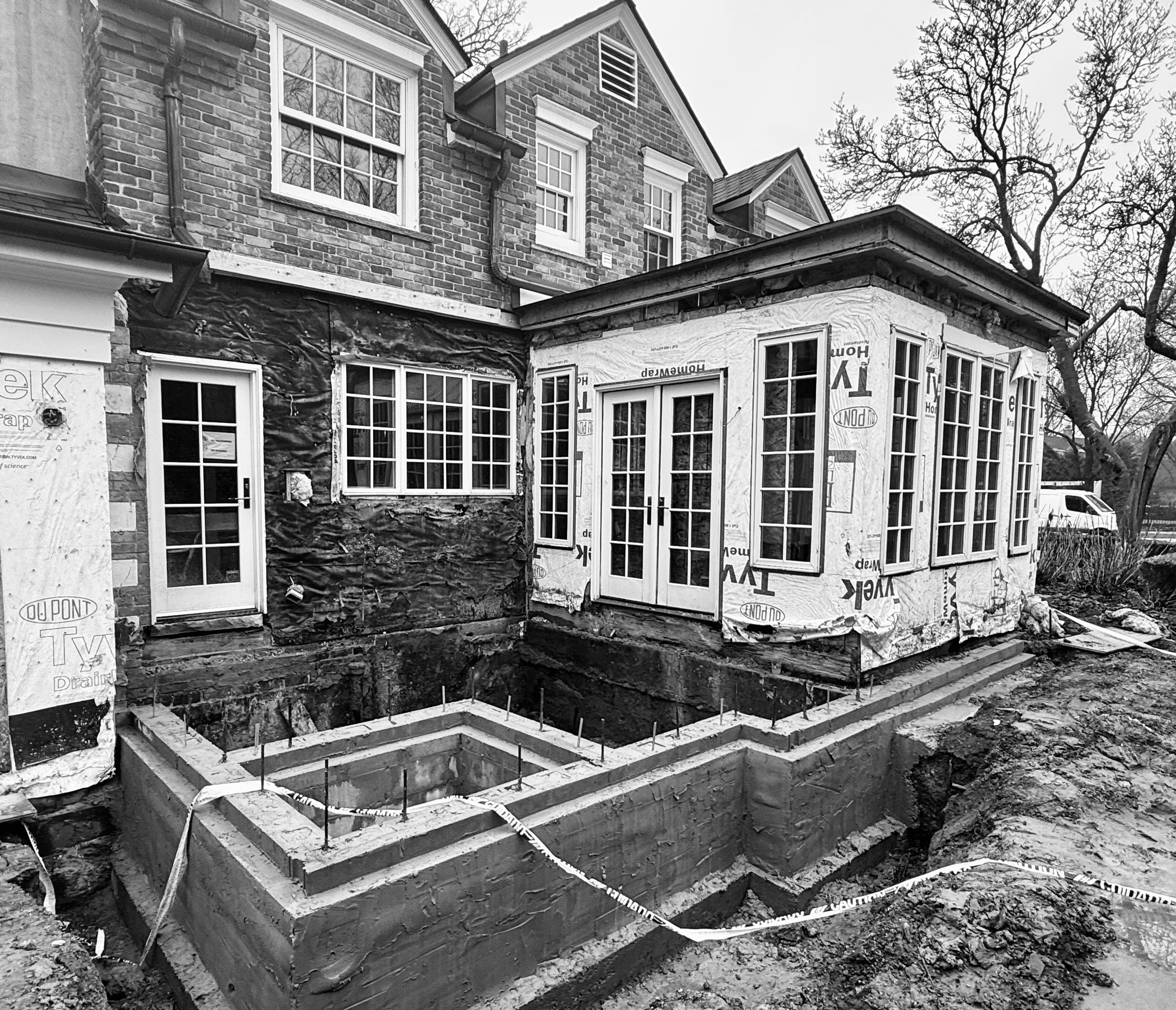 The original nook stripped to its sheathing, with the new foundation poured and the larger footprint set.