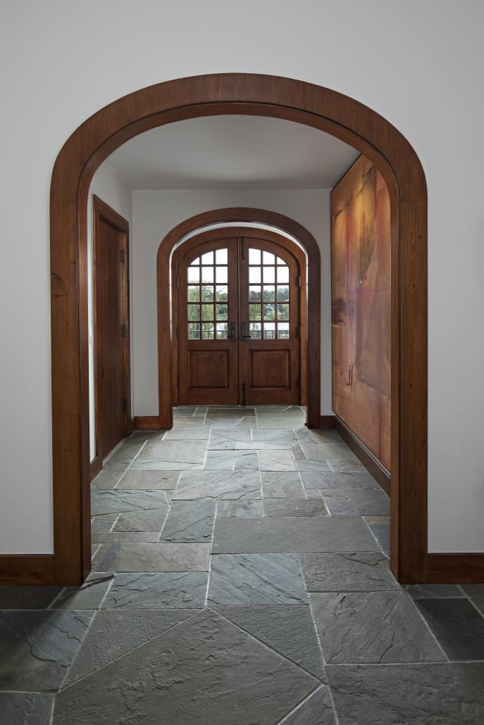 Arched mahogany doorway and slate floor at the entry
