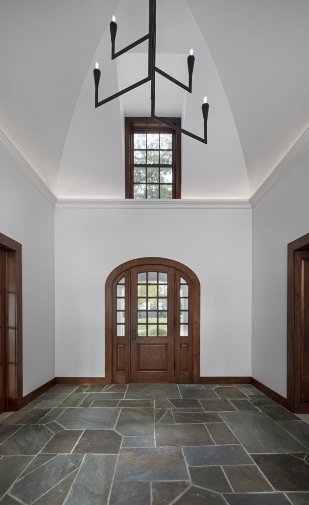 Vaulted hall with an iron chandelier and arched door